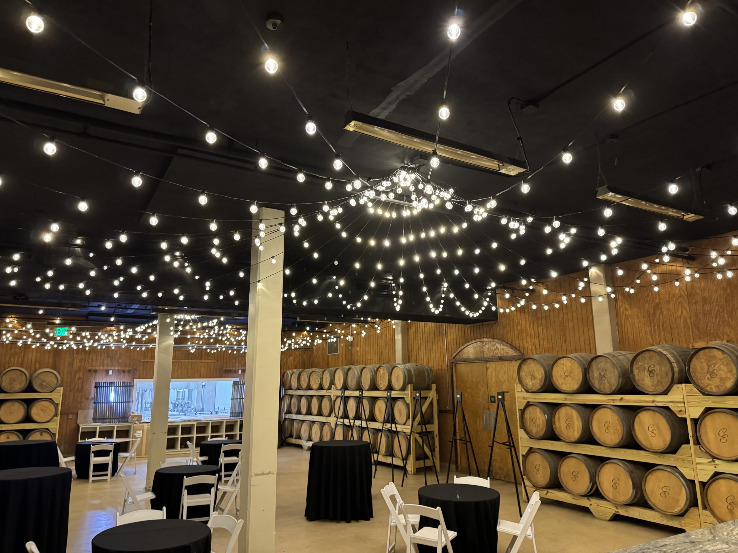 Outdoor bistro lights installed above the vineyard vines at Château Élan Winery by Georgia Lightscapes, creating a warm and inviting evening atmosphere.