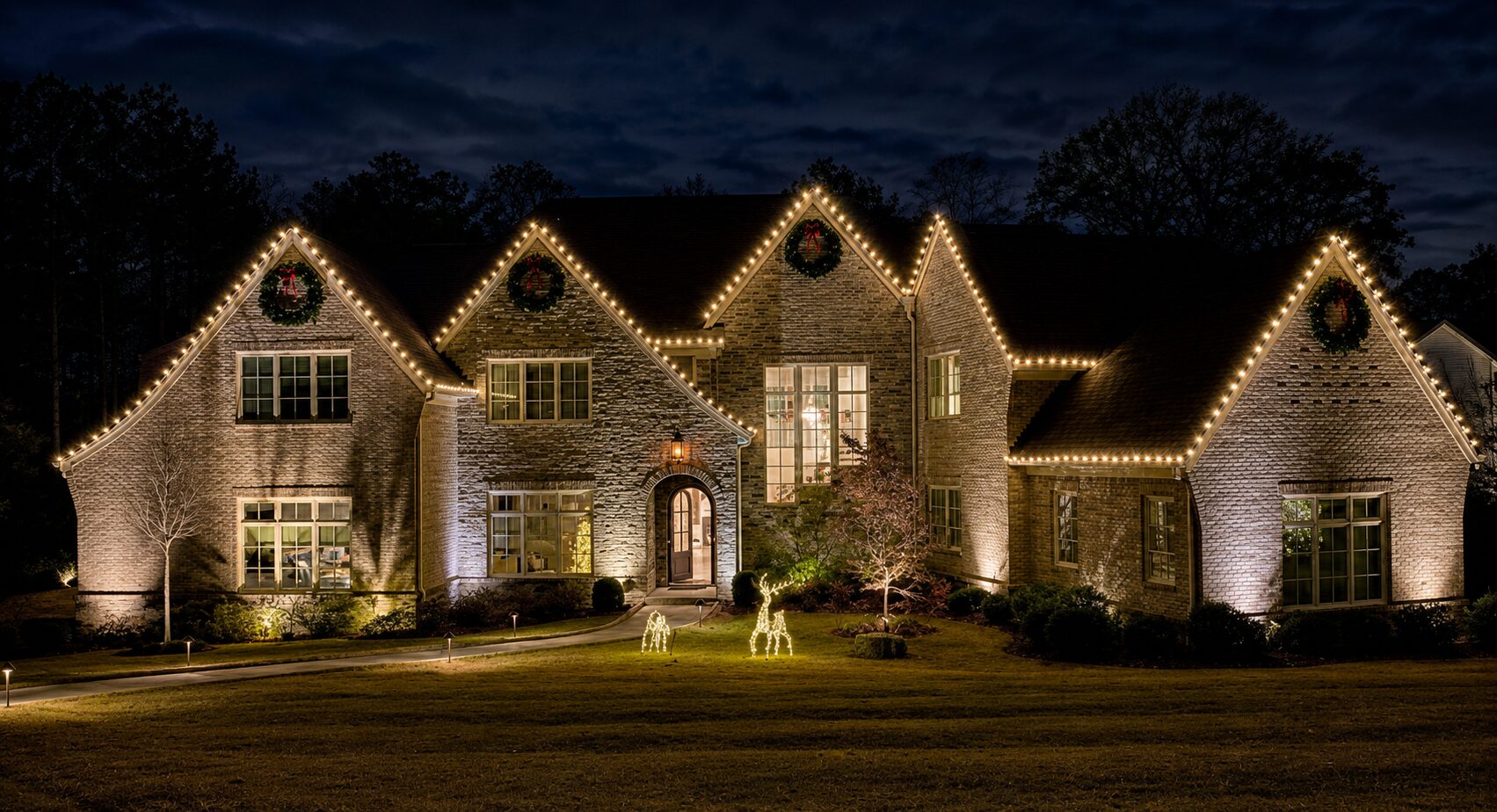Luxury home in Canton decorated with warm-white Christmas roofline lights and wreaths by Georgia Lightscapes.