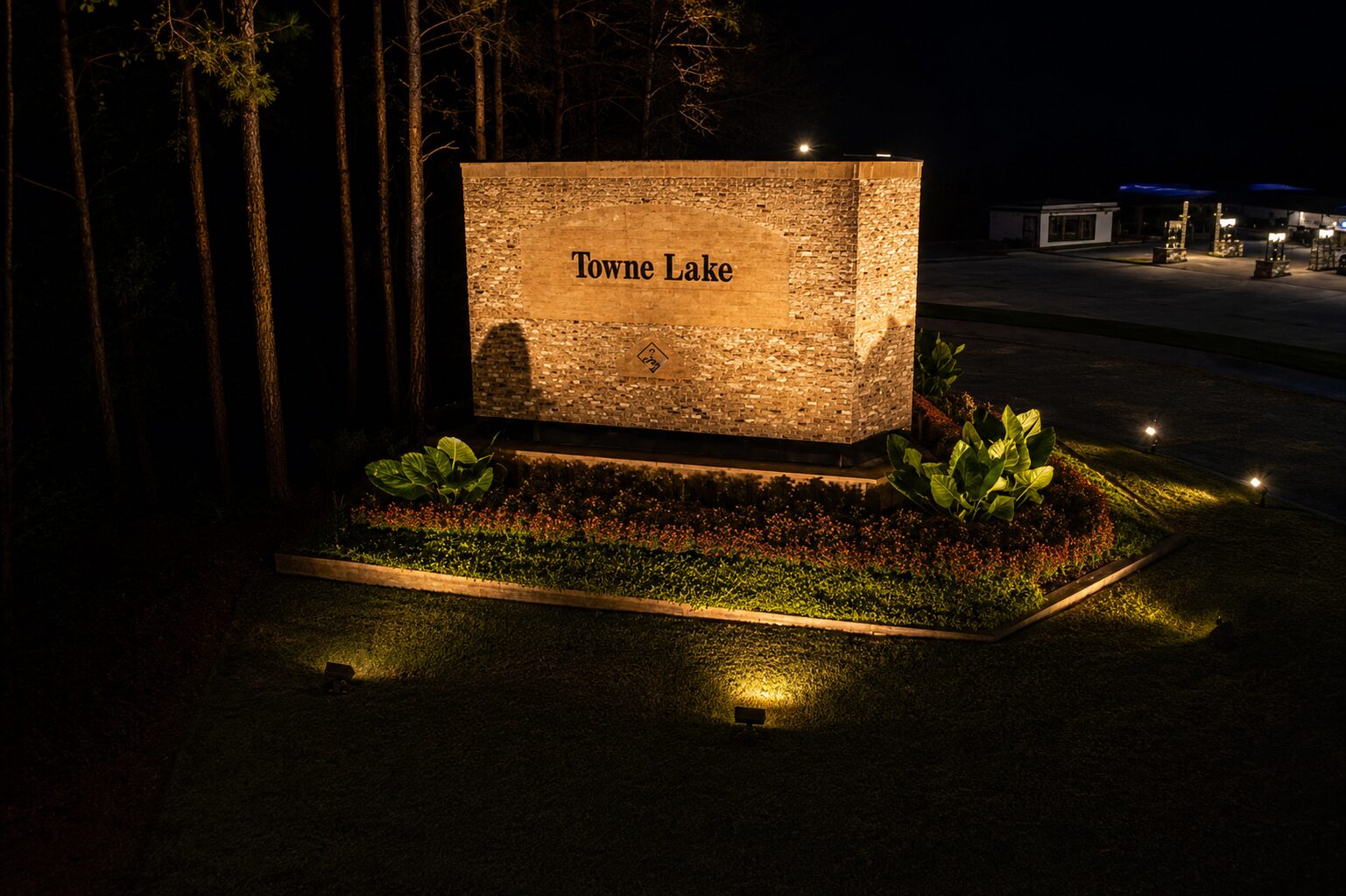 Professionally illuminated Towne Lake HOA entrance monument sign with landscape lighting in Woodstock, Georgia.